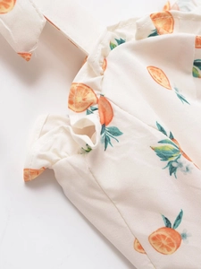 Détail du tissu blanc avec imprimé agrumes orange et coutures à volants élégantes