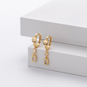 Detail of gold star earrings with micro-set cubic zirconia and rectangular pendant