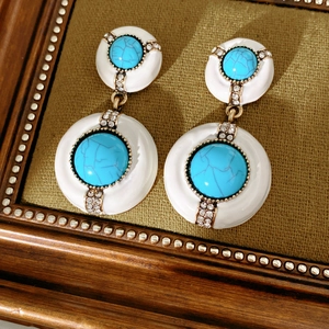 Close-up of vintage resin earrings with turquoise stone and sparkling rhinestones