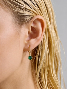 Close-up of S925 silver gold hoop earring with a round green zircon stone charm