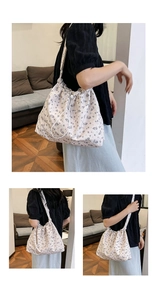 Detail of floral print shoulder bag with drawstring closure and comfortable wide strap