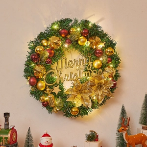 Christmas wreath with LED lights, gold flowers, and red baubles on green pine needles
