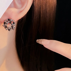 French retro hollow round stud earrings with black crystals on a female model