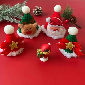 Detailed view of handmade knitted Christmas pet hats with reindeer and Santa motifs