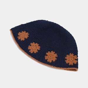 Close-up of crochet hollow flower pattern and thick knit texture on navy bucket hat