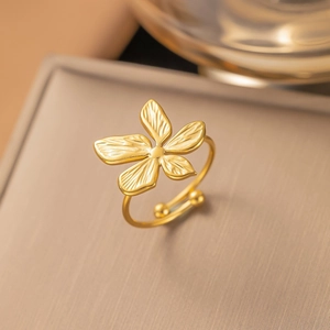 Bague fleur dorée ajustable avec design texturé à cinq pétales sur fond métallique