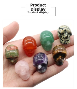 Close-up of seven assorted 1-inch natural crystal skull carvings held in a hand