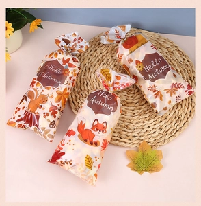 Detail of Hello Autumn gift bags with squirrels and maple leaves on a woven mat