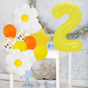 Detail of daisy flower balloons and a large yellow number two for birthday party decor
