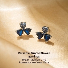 Macro shot of S925 silver stud earrings with blue heart-shaped cubic zirconia flower design