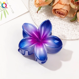 Detail of gradient blue-purple plumeria hair claw clip with pearlescent finish and glitter