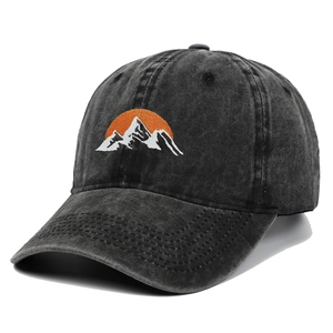 Close-up of mountain embroidery and washed cotton texture on a dark grey baseball cap
