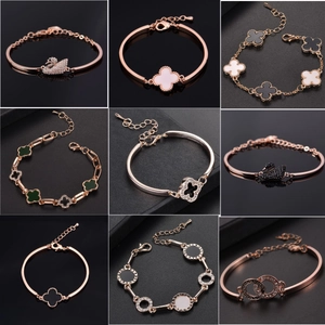 Macro view of rose gold bracelets featuring clover motifs and sparkling cubic zirconia details