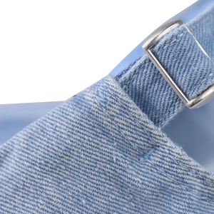 Detail of adjustable metal buckle on light blue washed denim baseball cap with twill texture
