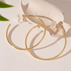 Detail of gold geometric hoop clip-on earrings with clear silicone comfort pads