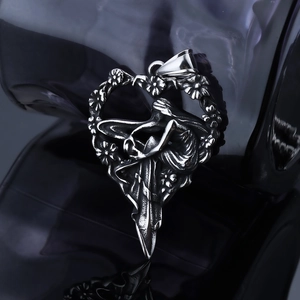 Macro shot of vintage silver heart pendant with intricate lady and floral carvings
