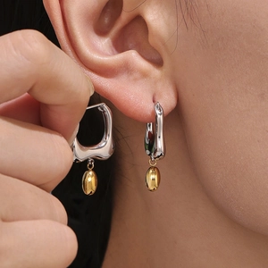 Minimalist irregular U-shaped two-tone stud earrings in polished silver and gold