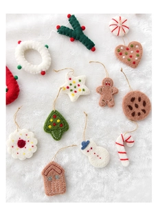 Flat lay of handmade wool felt Christmas ornaments including gingerbread man and snowman