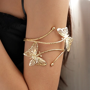 Détail d'un bracelet de bras papillon doré ajouré avec des ailes ciselées sur un mannequin