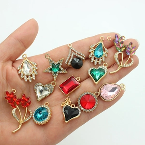 Star and heart shaped alloy charms with colorful rhinestones held in a hand