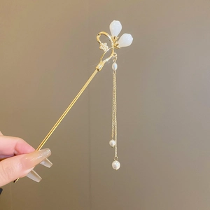 Détail d'une épingle à cheveux chinoise avec boutons blancs et glands en perles