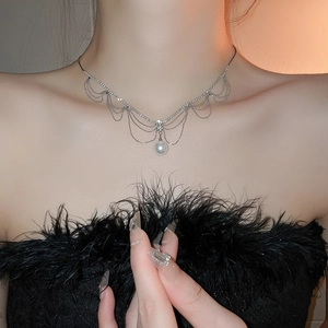 Détail d'un élégant collier à franges en dentelle avec diamants et pendentif perle