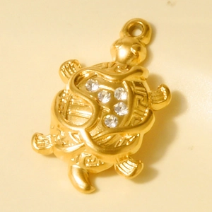 Macro view of 18k gold plated stainless steel turtle pendant with clear rhinestones