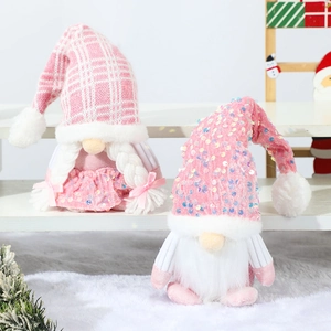 Pair of pink Christmas gnomes with sequin hats and knit details on snowy background