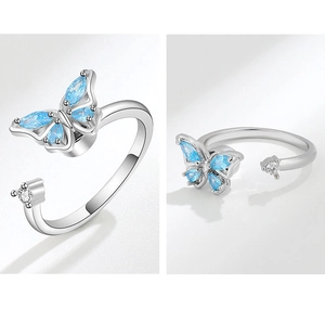 Detail view of rotating butterfly ring with blue and clear crystals on silver band