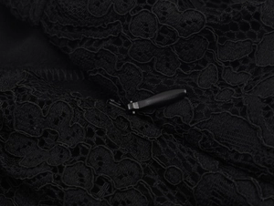 Gros plan sur la dentelle florale complexe et la fermeture éclair noire du pantalon