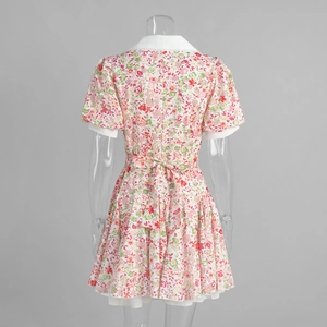 Detailed back view of floral short sleeve dress featuring waist tie bow and layered hemline