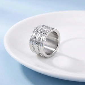 Macro shot of silver hammer-textured wide steel ring with sparkling pave crystals
