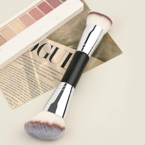 Dual-ended makeup brush with soft bristles placed on a stylish VOGUE magazine layout