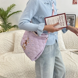 Detail of light purple quilted shoulder bag with cute cartoon animal embroidery