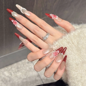Red and pink gradient press-on nails with 3D floral accents and diamond patterns