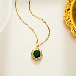 Close-up of gold oval emerald pendant with 925 silver hallmark and pavé zircon stones