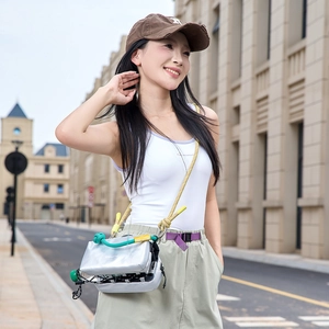 Outdoor model shot of silver reflective crossbody bag with yellow rope strap detail