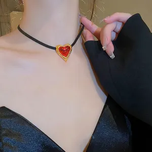 Vintage gold textured heart necklace with red translucent pendant and black cord