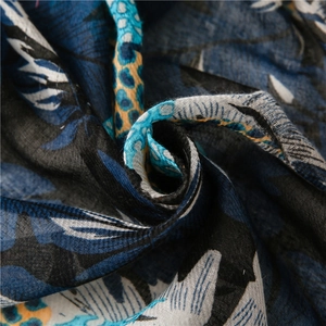 Soft navy blue linen-feel scarf with large leaf print for sun protection travel wrap