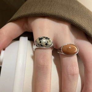 Detail of two oval gemstone rings with dalmatian jasper and brown agate on a silver band
