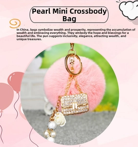 Close-up of pink faux fur pompom keychain with crystal encrusted bag charm and pearls