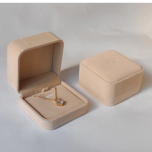 Macro detail of beige velvet jewelry boxes showing interior padding and soft texture