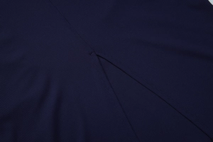 Macro detail of navy blue ribbed knit fabric with precise V-shaped slit stitching