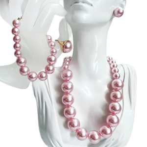 Elegant pink pearl jewelry set featuring necklace, bracelet, ring and earrings on model