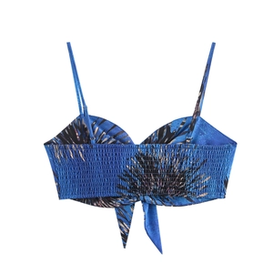 Detail of blue palm leaf print crop top with smocked back and delicate self-tie hem