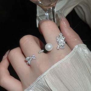 Macro detail of bow-knot zircon ring with elegant white pearl on model hand
