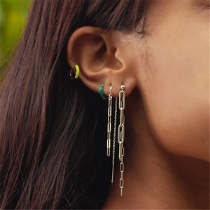 Close-up of S925 sterling silver paperclip chain tassel earrings worn by a model