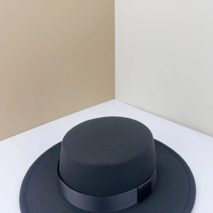 Close-up of black wool felt boater hat with ribbed ribbon band and wide flat brim