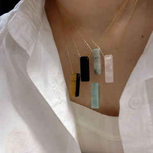 Minimalist rectangular natural crystal bar pendant necklace on a gold metal chain