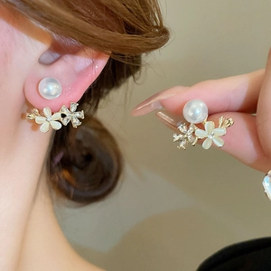 Elegant floral pearl earrings with opal petals and gold finish on female model